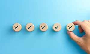 Checklist,Concept,,Check,Mark,On,Wooden,Blocks,,Blue,Background,With