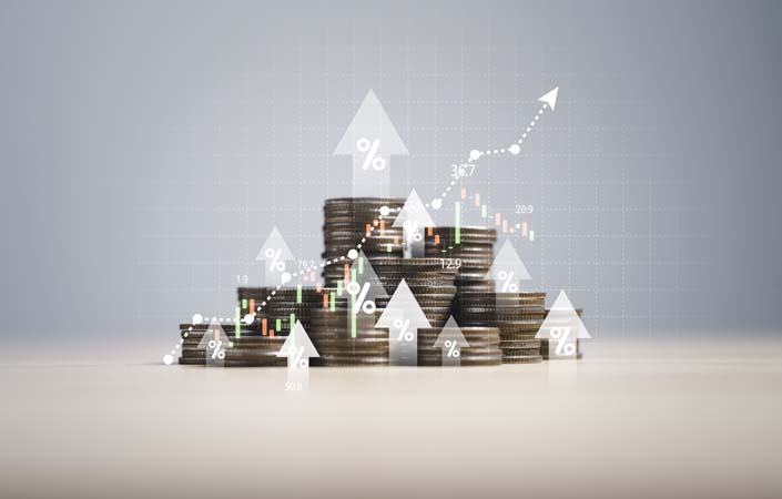 Heap of coins money with up arrow and stock market chart for financial banking increase interest rate or mortgage investment dividend from business growth concept.