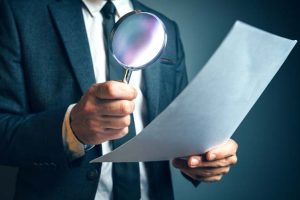 Lawyer reading legal contract agreement disclaimer with magnifyi