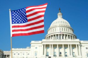 American,Flag,Flying,In,Sunny,Blue,Sky,In,Front,Of