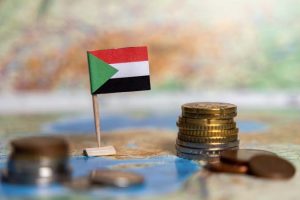 Sudan,Flag,On,A,Toothpick,Near,A,Stack,Of,Coins,