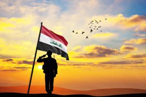 Silhouette,Of,A,Soldier,With,The,Iraq,Flag,Stands,Against