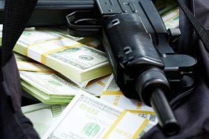 Close-up,Of,Black,Weapon,Lying,On,Heap,Of,Hundred,Dollar
