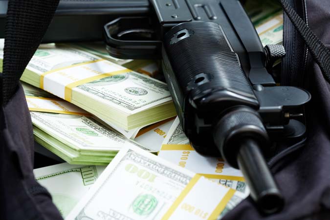 Close-up,Of,Black,Weapon,Lying,On,Heap,Of,Hundred,Dollar