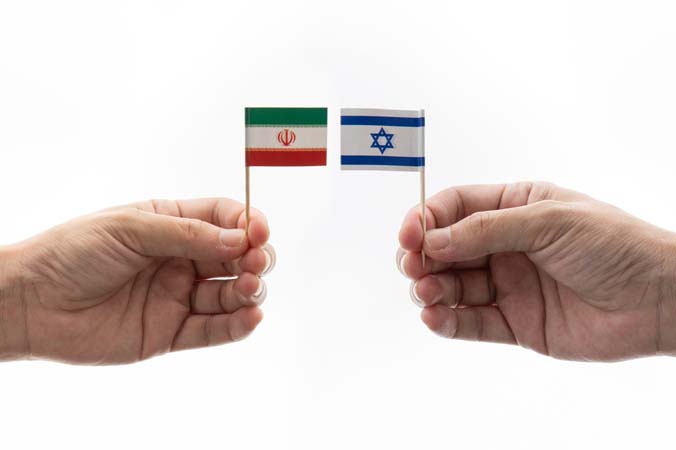 Two,Hands,Hold,Small,Miniature,Flags,Iran,And,Israel,Against